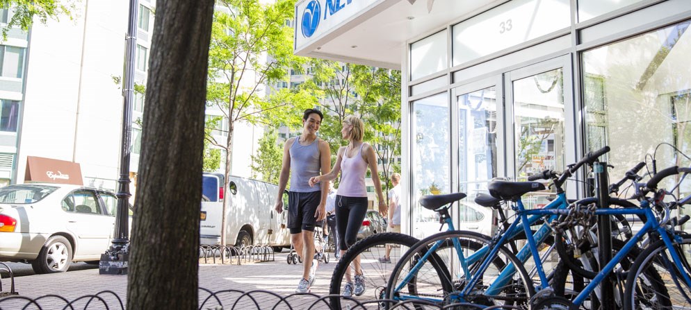 a man and a woman walking down a city street with bikes